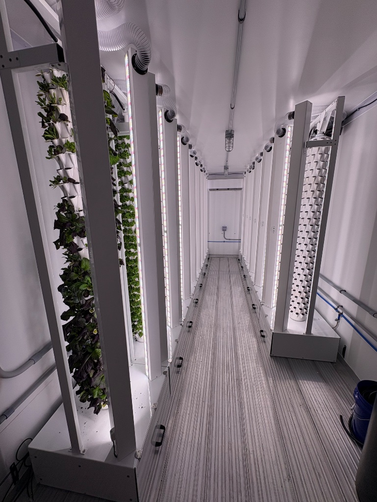 Container farm interior with vertical grow towers and LED lights