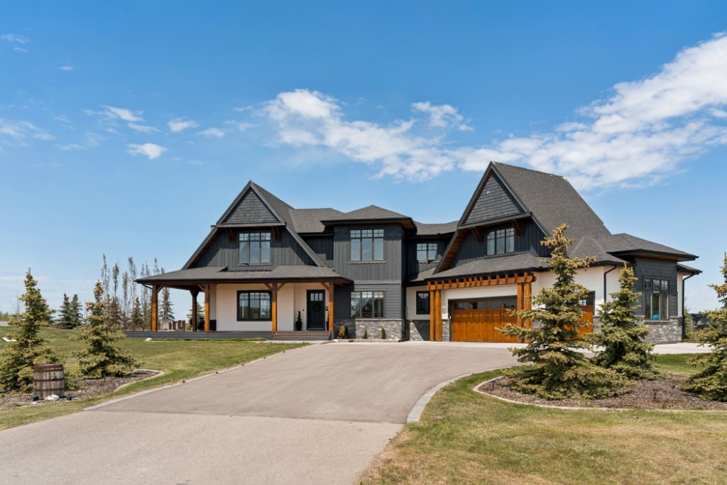 Luxury mountain-modern estate home in Bearspaw Alberta — matte black cladding, cedar timber accents and natural stone — custom acreage property near Calgary