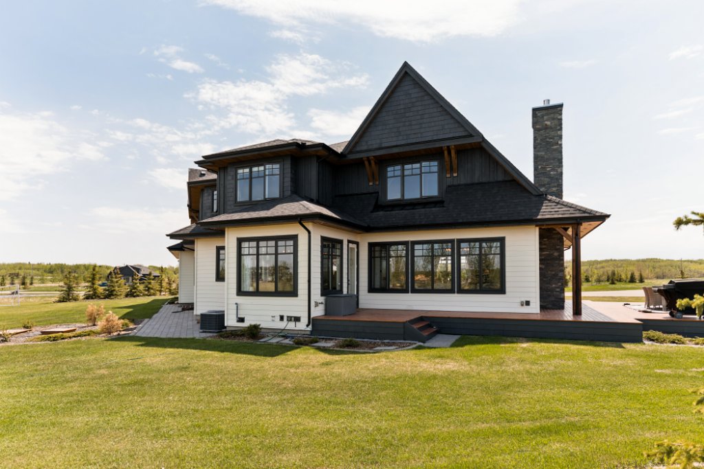 Cedar deck with covered outdoor entertaining space — luxury acreage home near Calgary Alberta with mountain modern architectural detailing