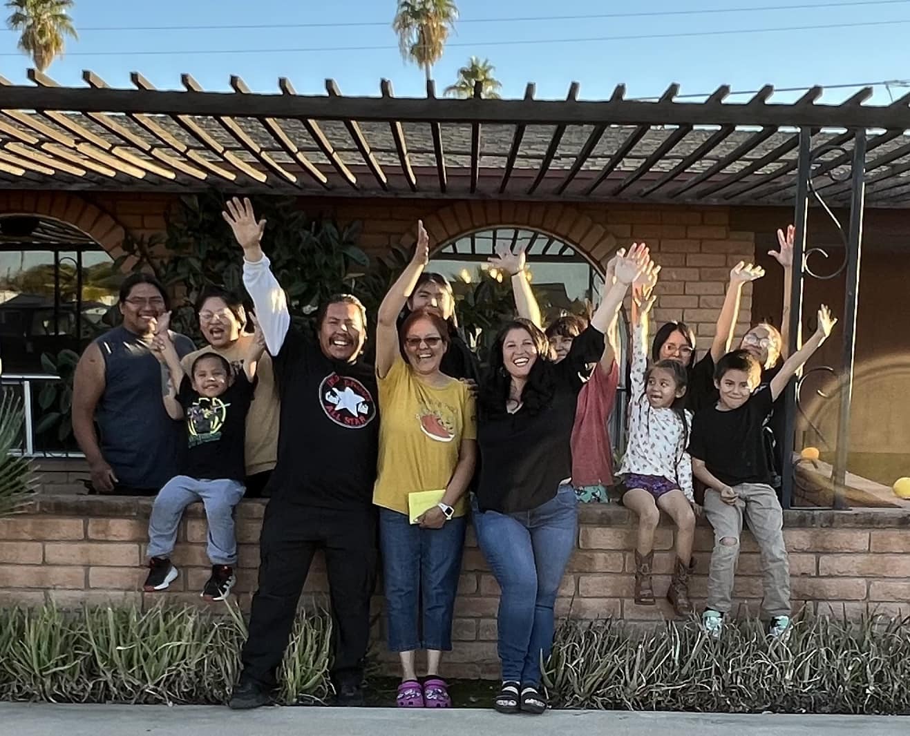 Large family celebrating in front of their brick home