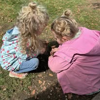 Two children exploring nature outdoors together