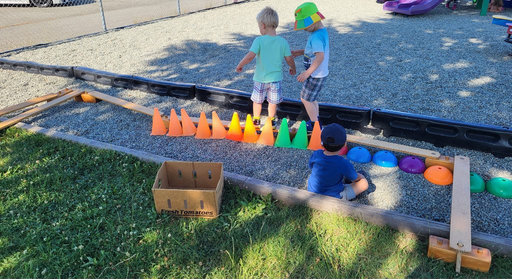 Children playing with cones in the outdoor sandbox