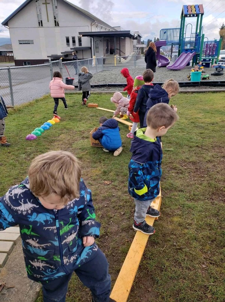 Children playing on balance beams outdoors