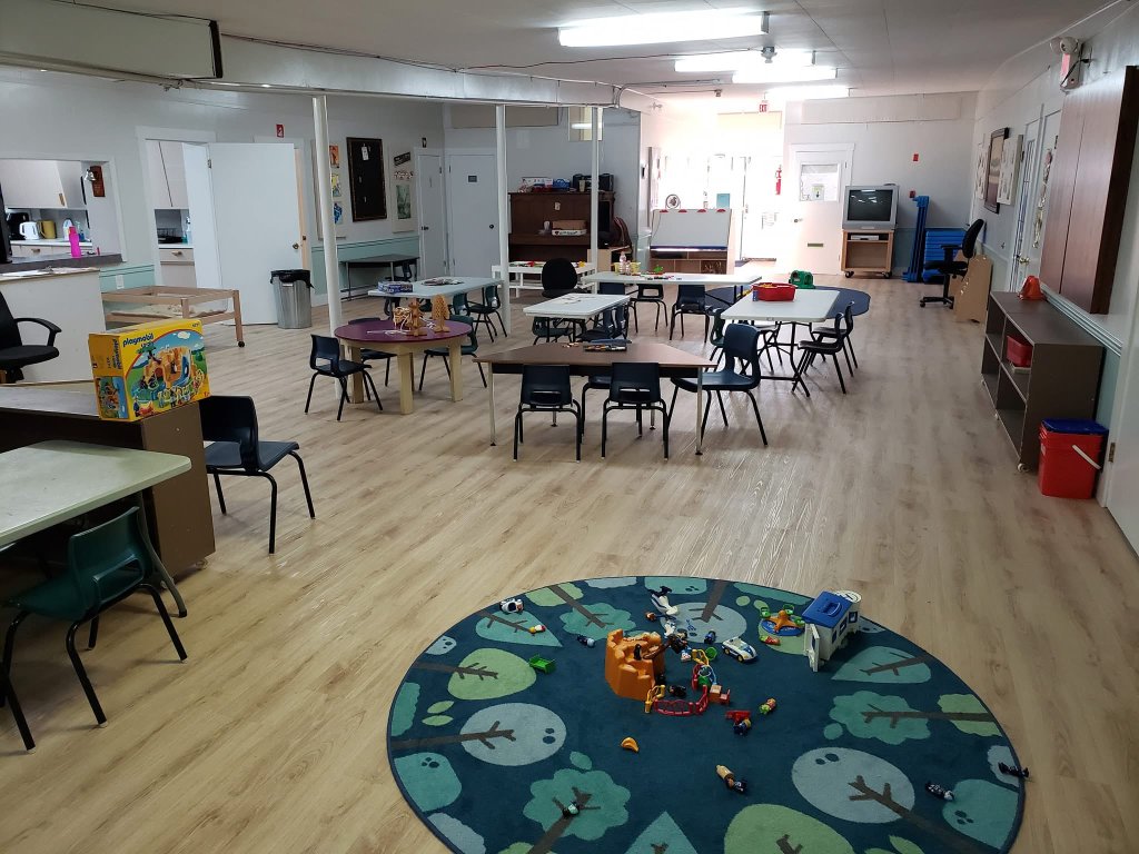 Spacious classroom with tables and play areas