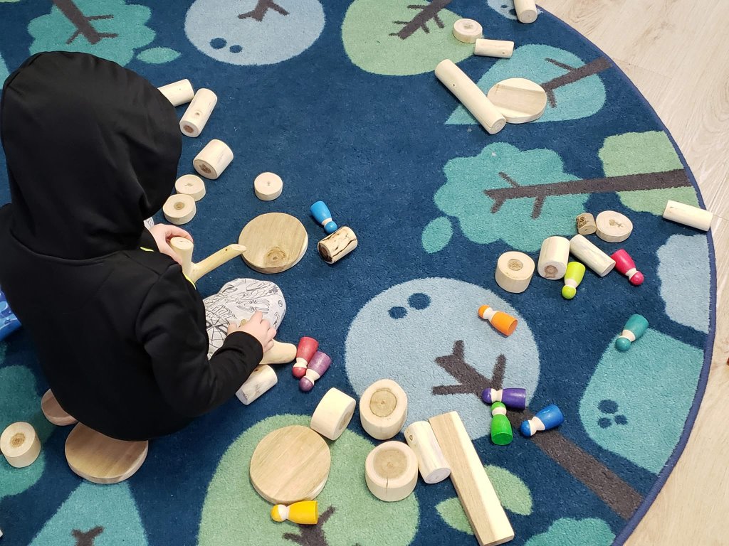 Children playing with wooden toys on carpet