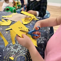 Child cutting paper shapes with scissors