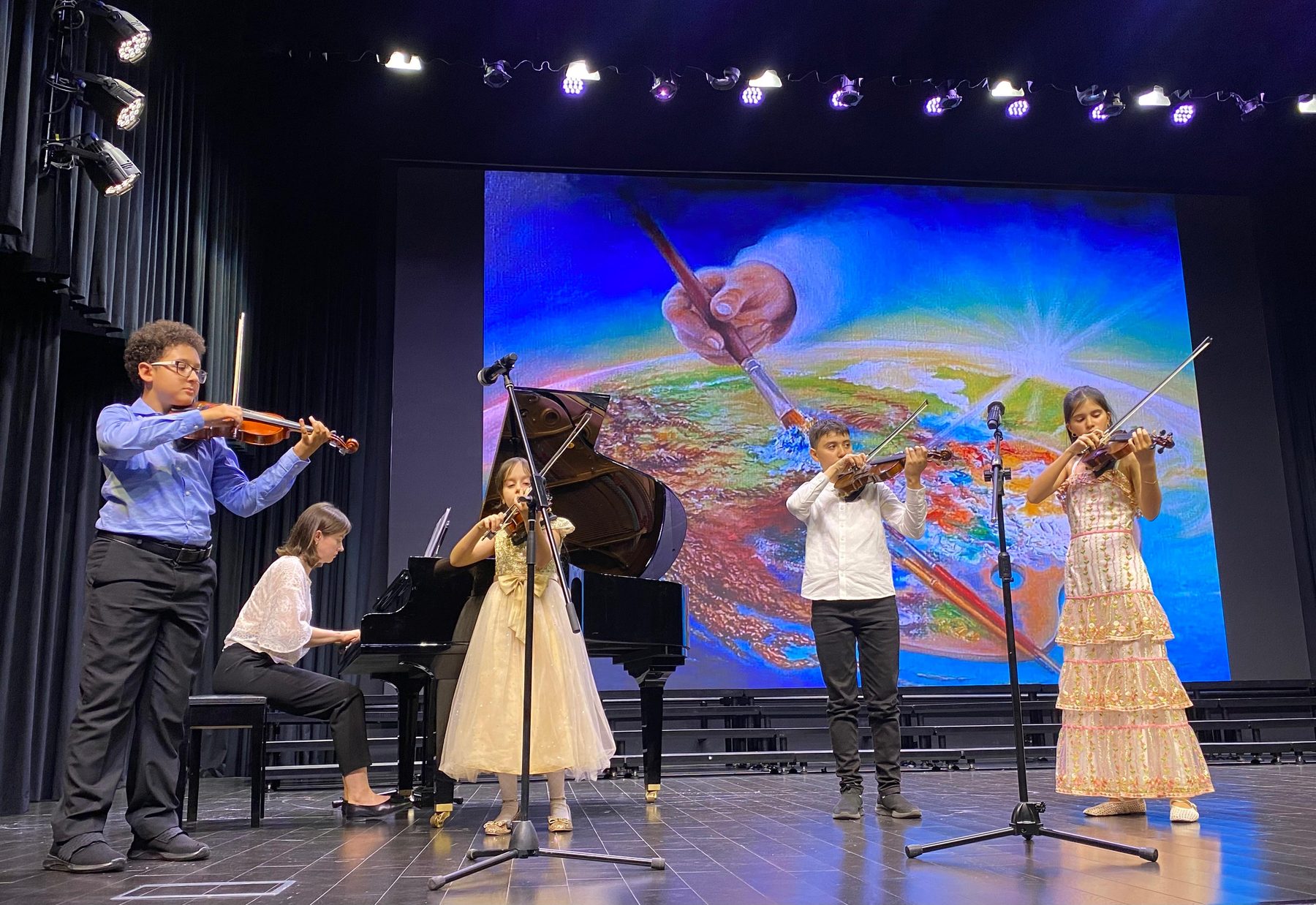 Violin quartet and pianist performing