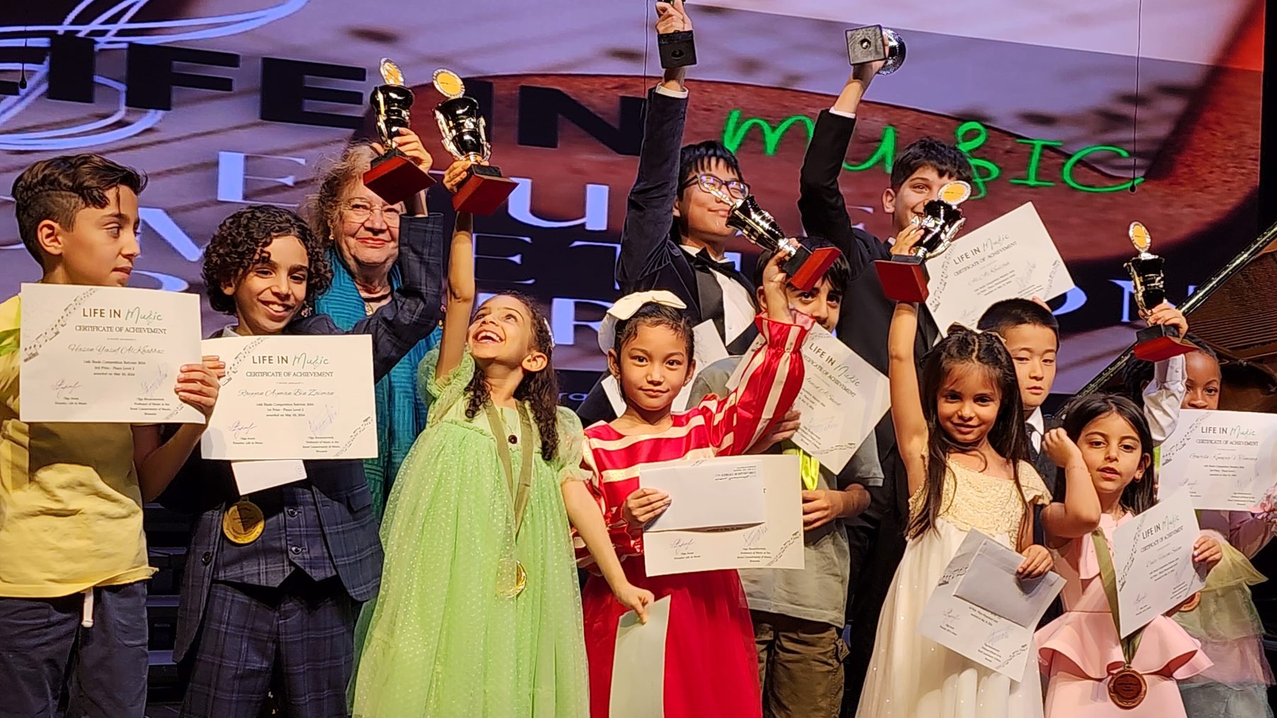 Students celebrating with trophies at the Etude Competition