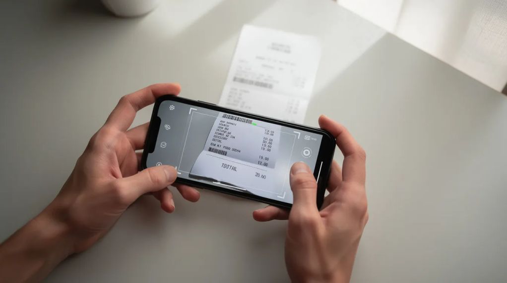 Smartphone scanning a paper receipt to keep digital copies for HMRC compliance