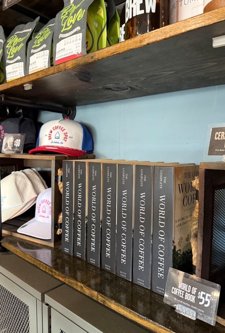 Copies of The Complete World of Coffee on the shelf at Brew Coffee Spot, a cafe in La Mesa