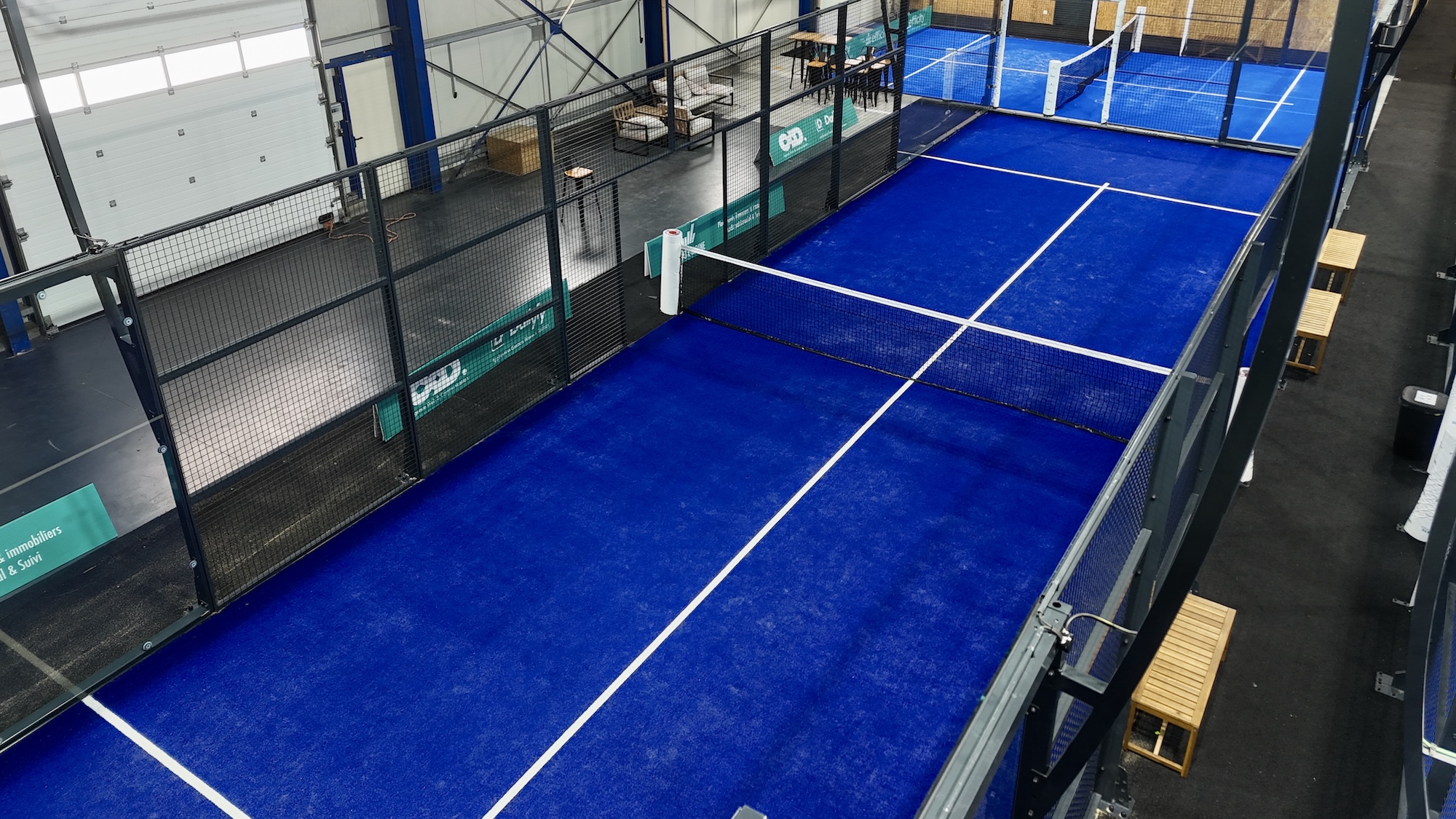 Vue plongeante des terrains de padel bleus du club Glaz Padel à Dinard