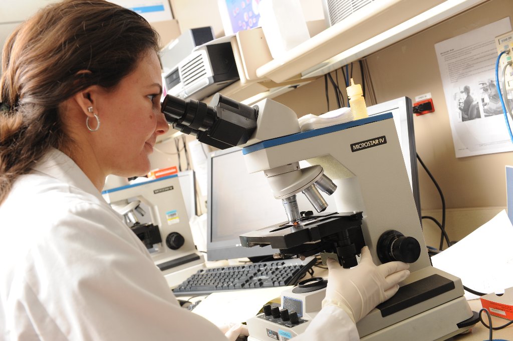 Researcher at microscope in lab