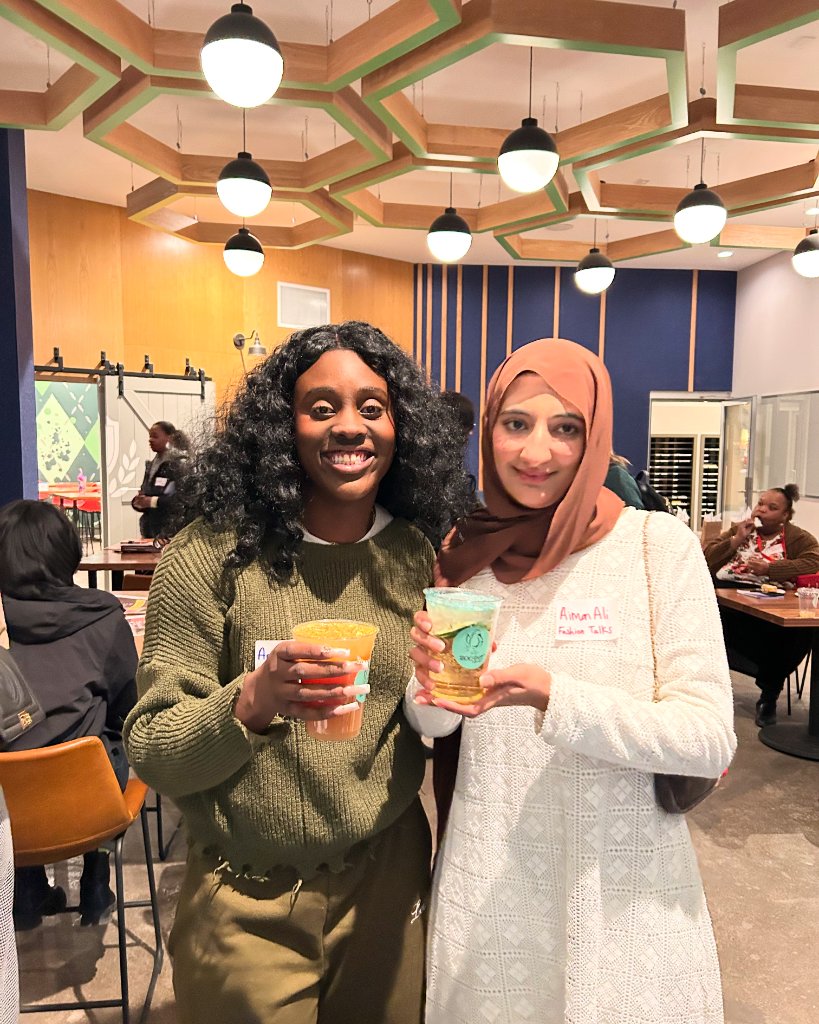 Two women holding Boobys drinks at an event