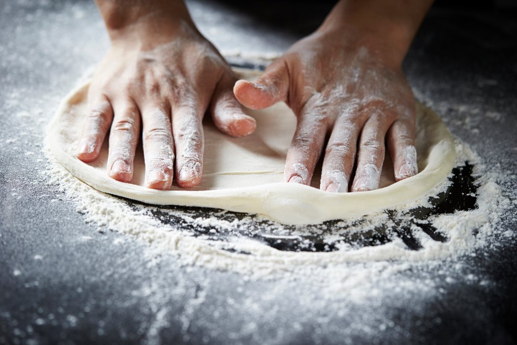 Handgjord pizzadeg knådas för hand