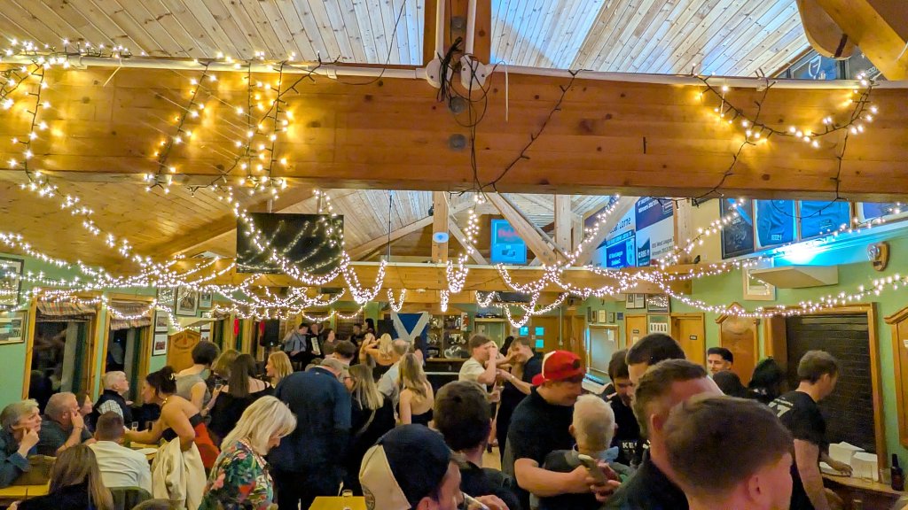 The Oban Lorne RFC clubhouse on an event night, lit with warm fairy lights across the wooden beams