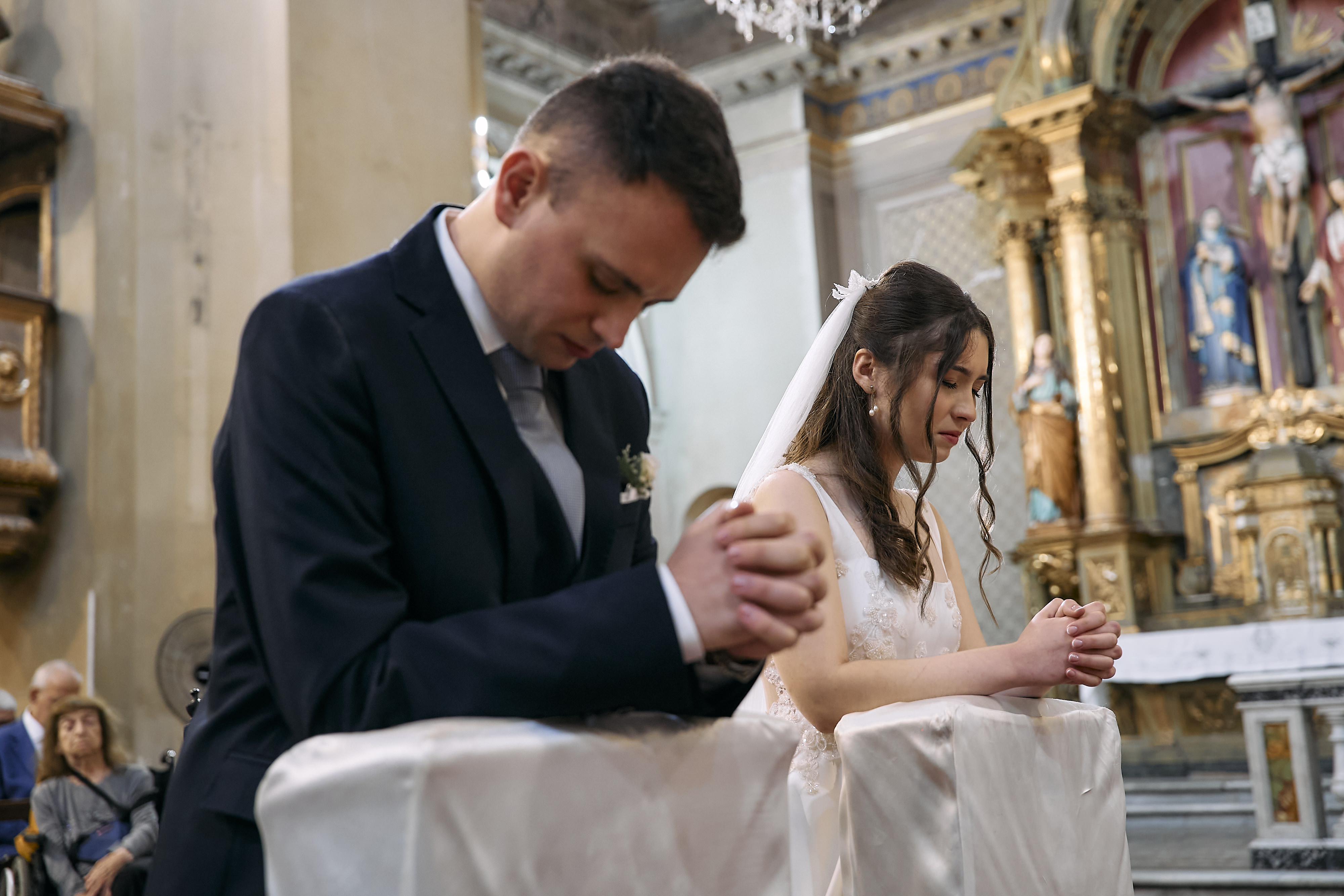 Los novios rezando arrodillados frente al altar durante la ceremonia religiosa