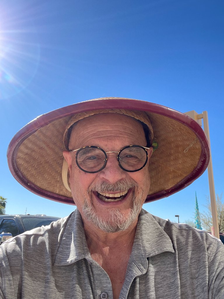 Ron wearing a straw conical hat during his travels in Indonesia