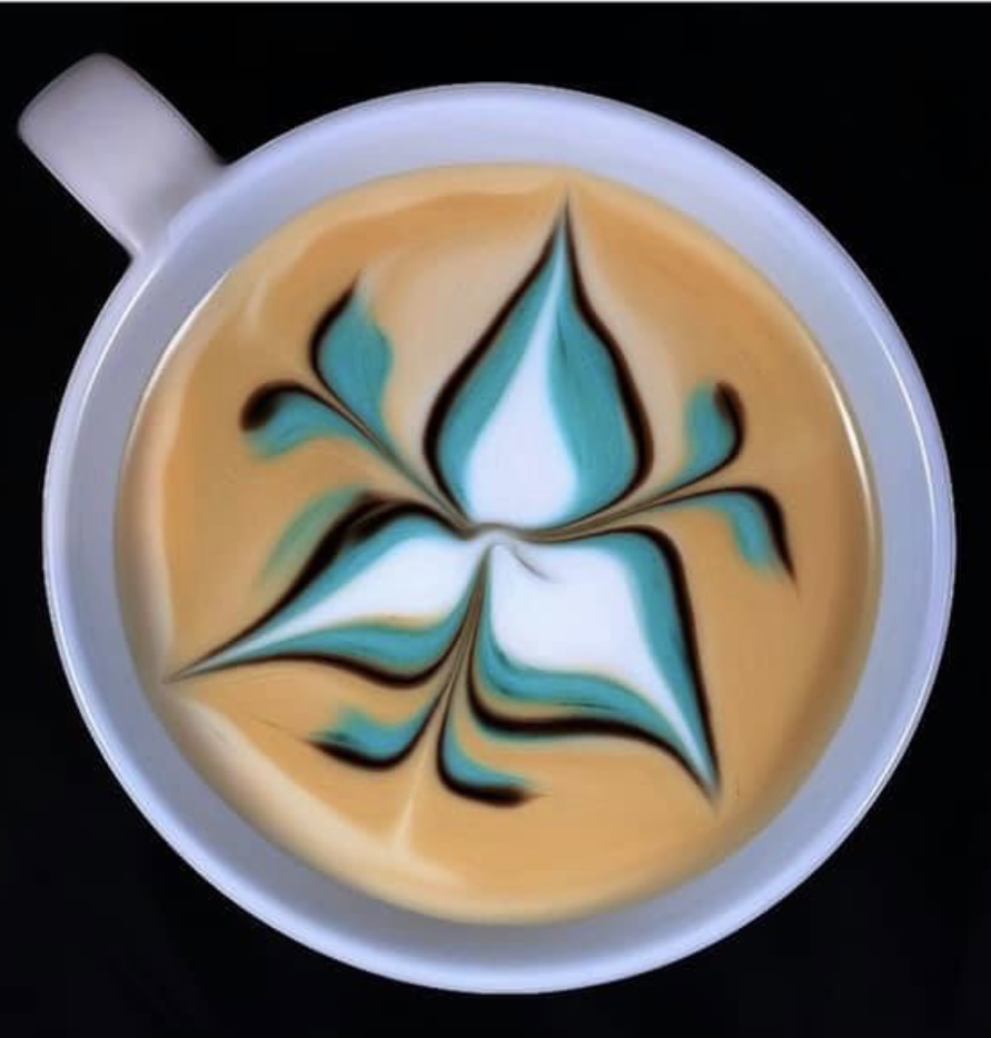 Colorful floral latte art in a white mug on a black background