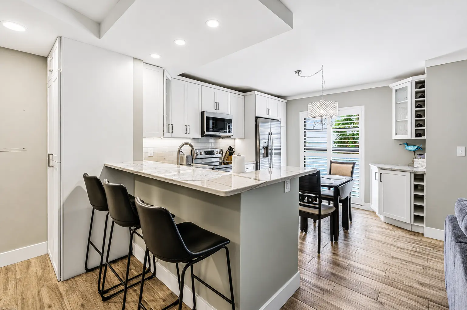 Kitchen island with quartz countertops and bar seating at Bottlenose Pointe vacation rental Marco Island