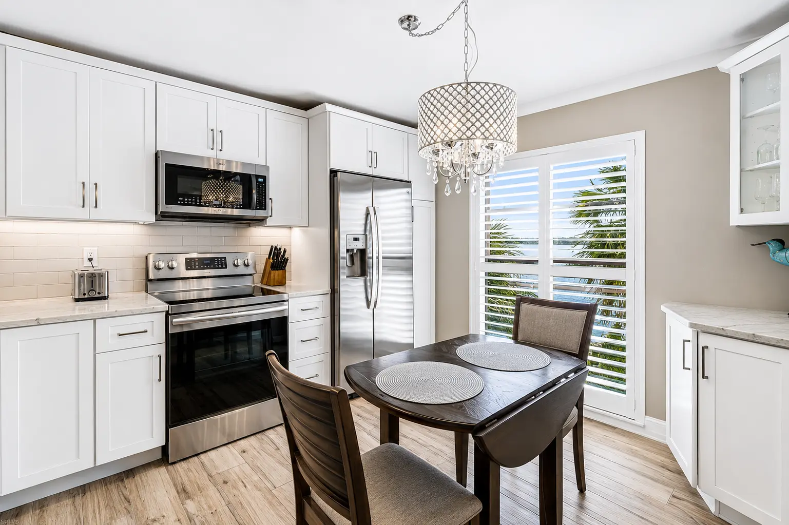 Kitchen dining area with plantation shutters and natural light at Bottlenose Pointe Marco Island vacation rental