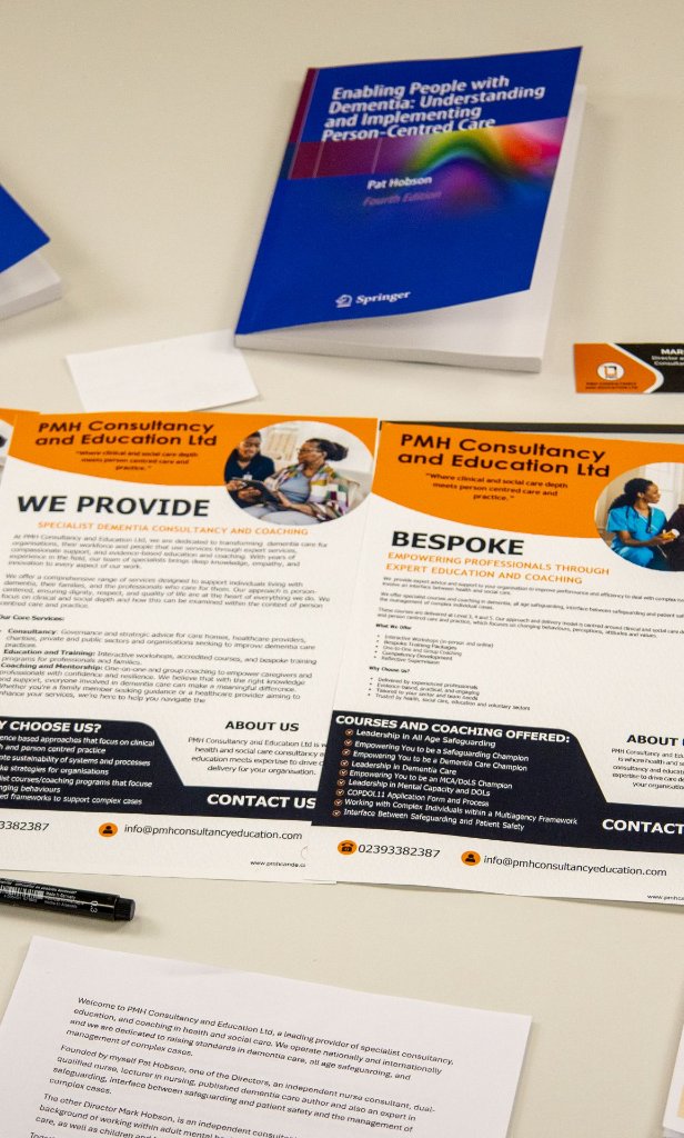 PMH Consultancy and Education advertising materials, including Pat Hobson's dementia book and PMH leaflets, at a conference display