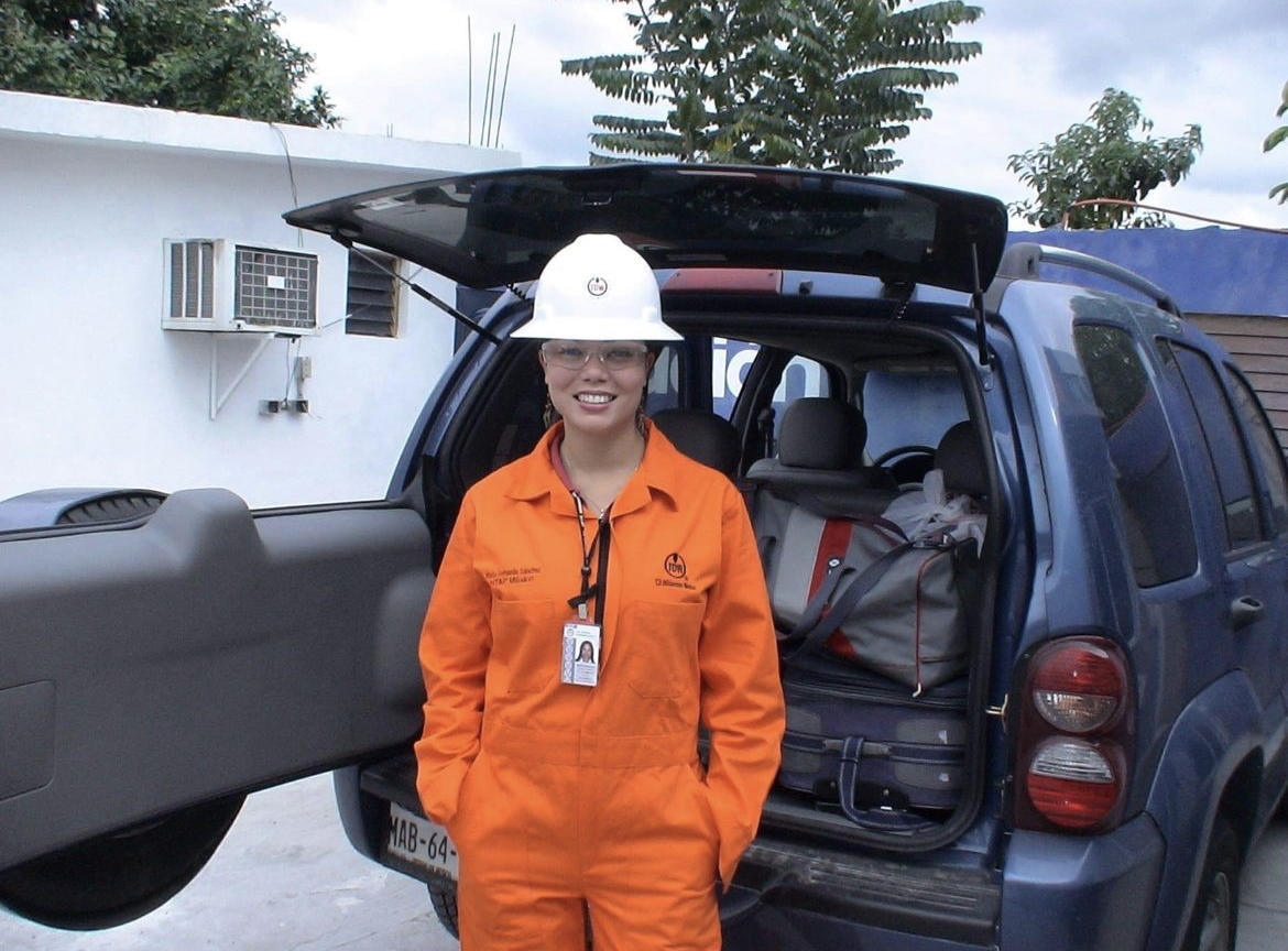 Maria during her engineering days, in work gear in front of a field vehicle