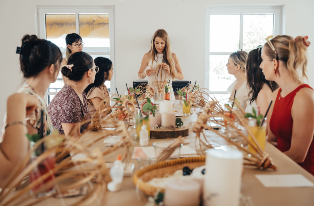 Workshop-Leiterin Rebecca Mattick demonstriert einer Gruppe von Frauen den Bau einer vietnamesischen Laterne im Atelier Lichtmomente Düsseldorf