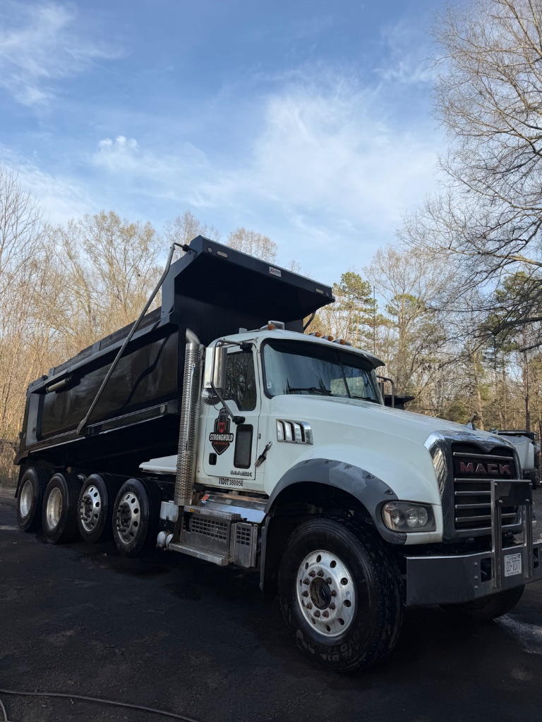 Heavy duty dump truck hauling construction materials at job site in Charlotte NC