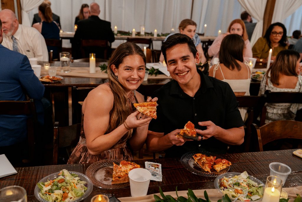 Couple smiling with pizza slices
