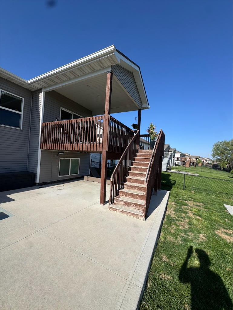 Before - Aging wood deck with worn railing, before Akin Brothers deck builders transformed it with composite decking in North Ankeny, Iowa