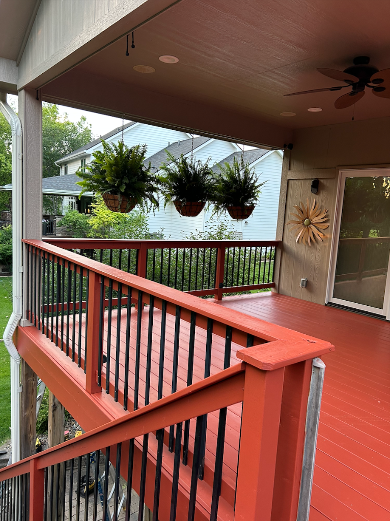 After - Deck railing detail with hanging plants after solid stain refinishing by Akin Brothers deck builders