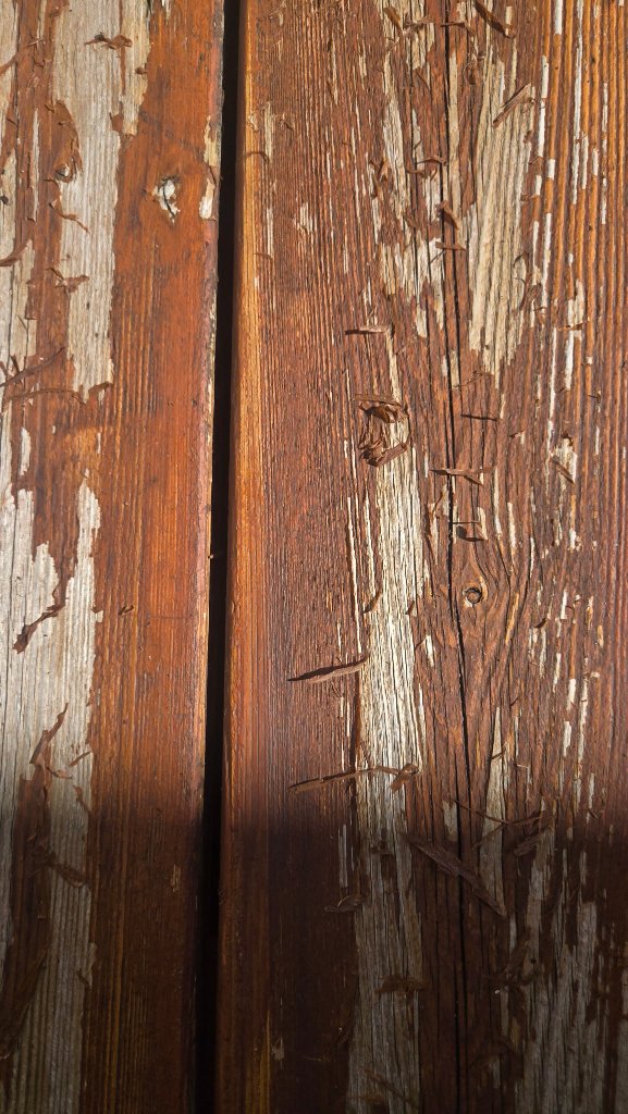 Before - Close-up of failing stain and wood damage on deck surface, before deck refinishing by Akin Brothers Construction