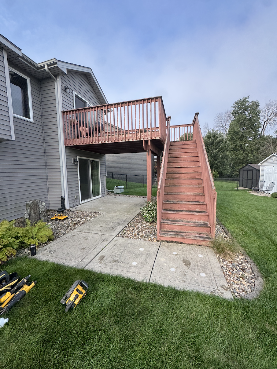 Before - Old weathered wood deck and staircase with faded stain, before Akin Brothers deck builders replaced it with a covered composite deck in Ankeny, Iowa