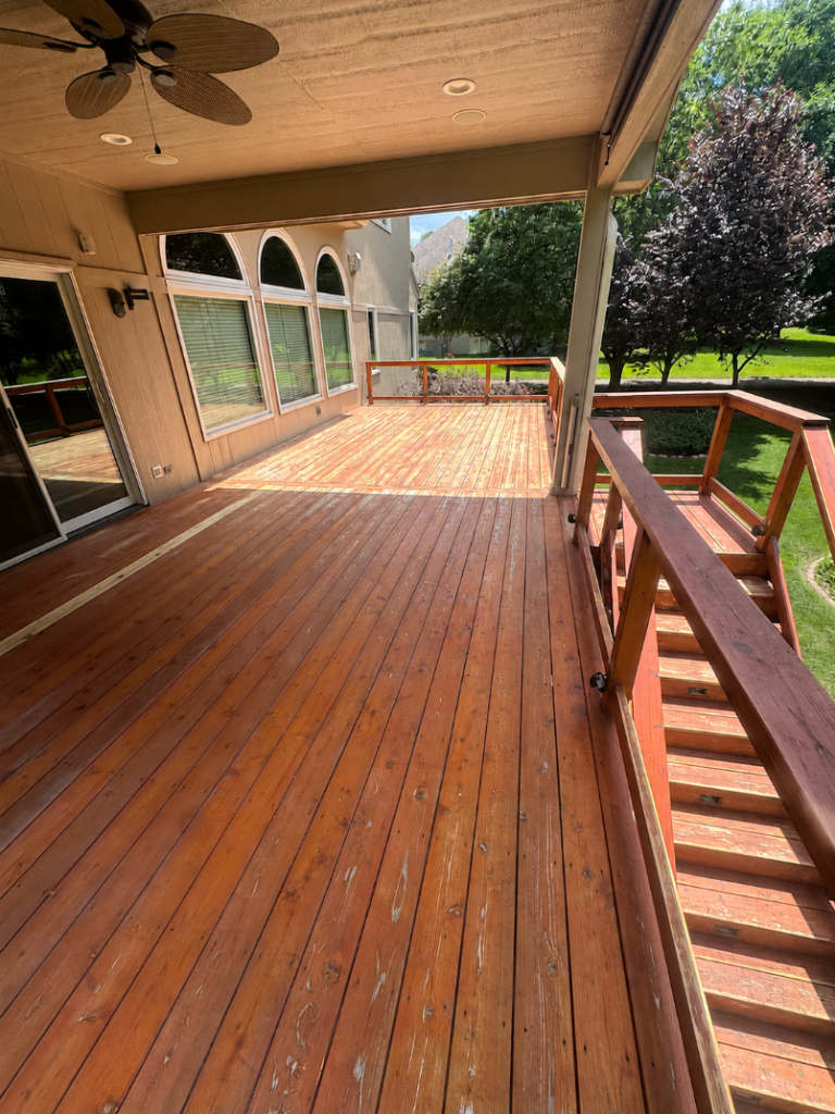 Before - Full deck surface showing worn and weathered stain, before deck refinishing by Akin Brothers deck builders in Central Iowa