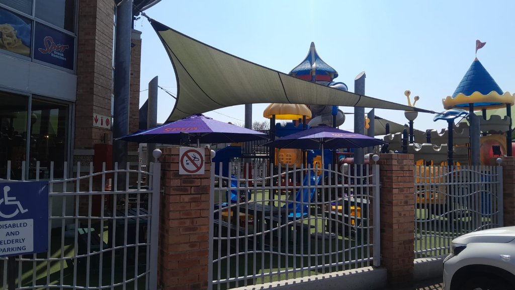 Spur branded umbrellas at outdoor play area
