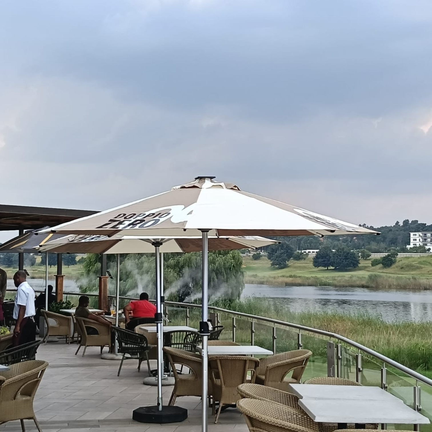 4-Panel Branded Solaris umbrella with DOPPIO ZERO branding on a restaurant patio