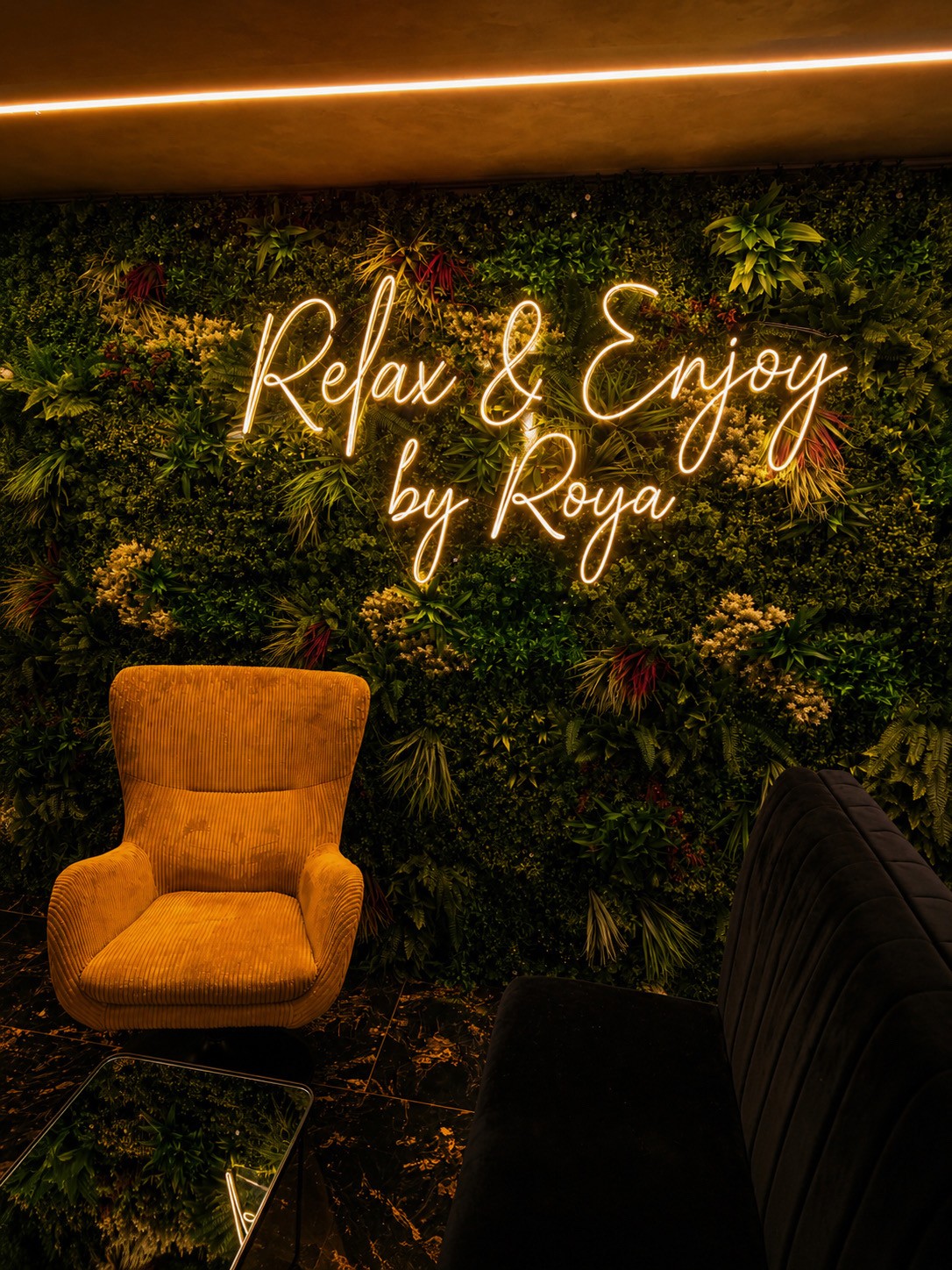 ROYA Lounge – Sitzbereich mit Pflanzenwand