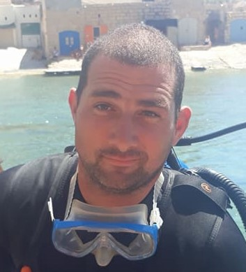 Diver swimming through the Inland Sea tunnel in Gozo