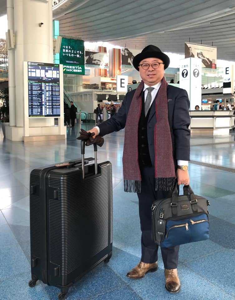 Brian B. Su, Asia Travel Advisor, at a train station in formal business attire