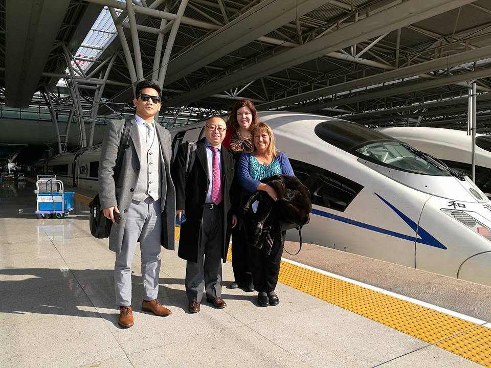 Brian B. Su with a delegation at a high-speed rail station in Asia
