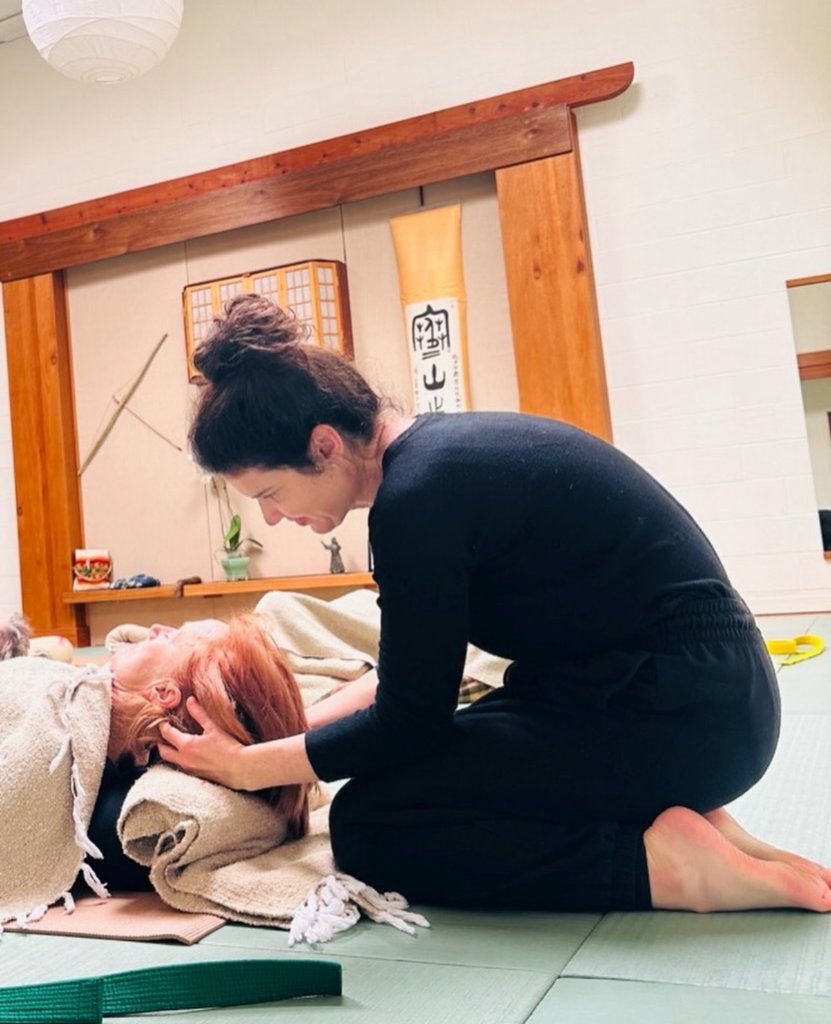 Sammi helping a student during a therapeutic yoga class