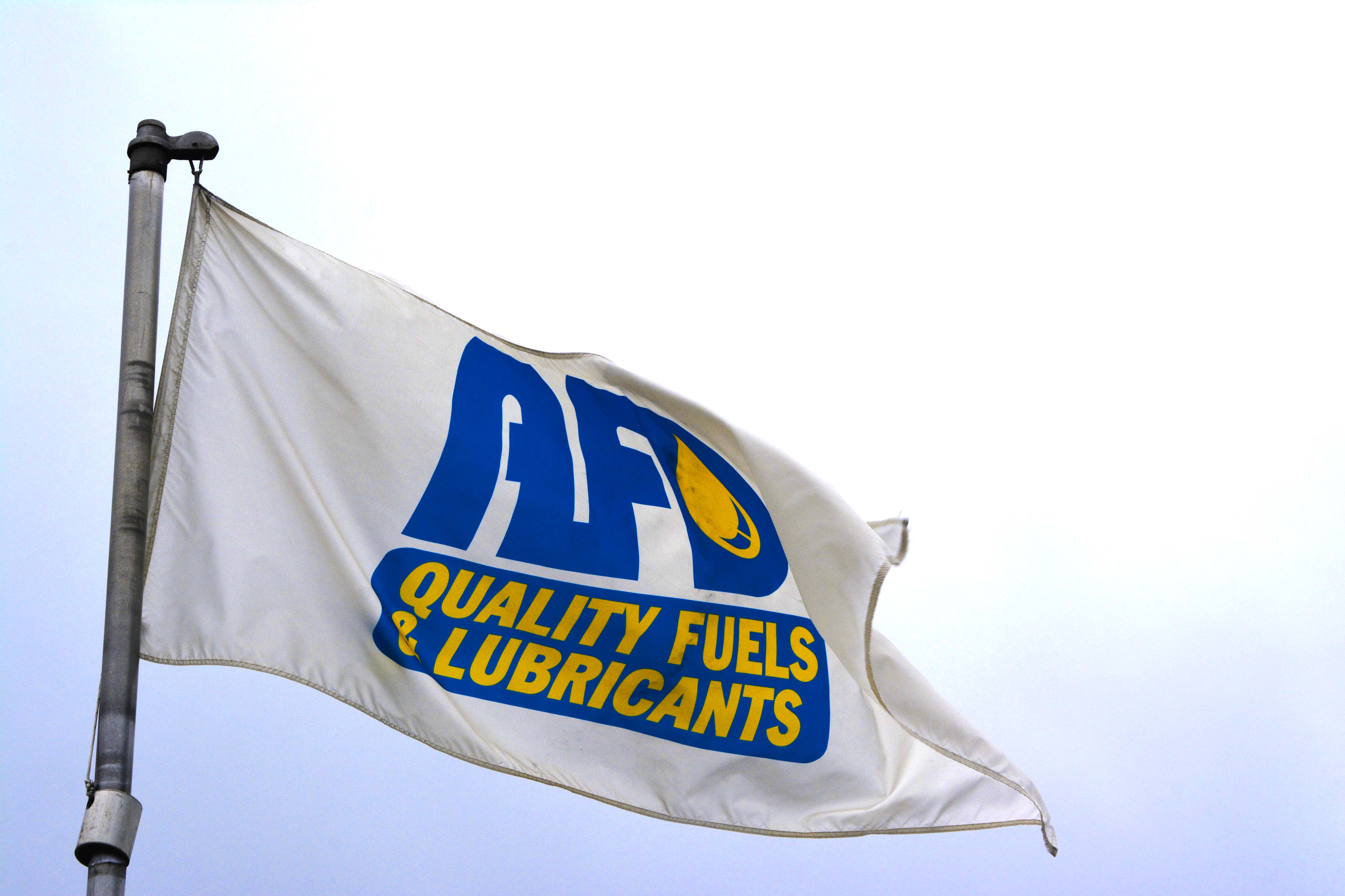 Close-up of the AFD Petroleum flag waving against an overcast sky at the Victoria location