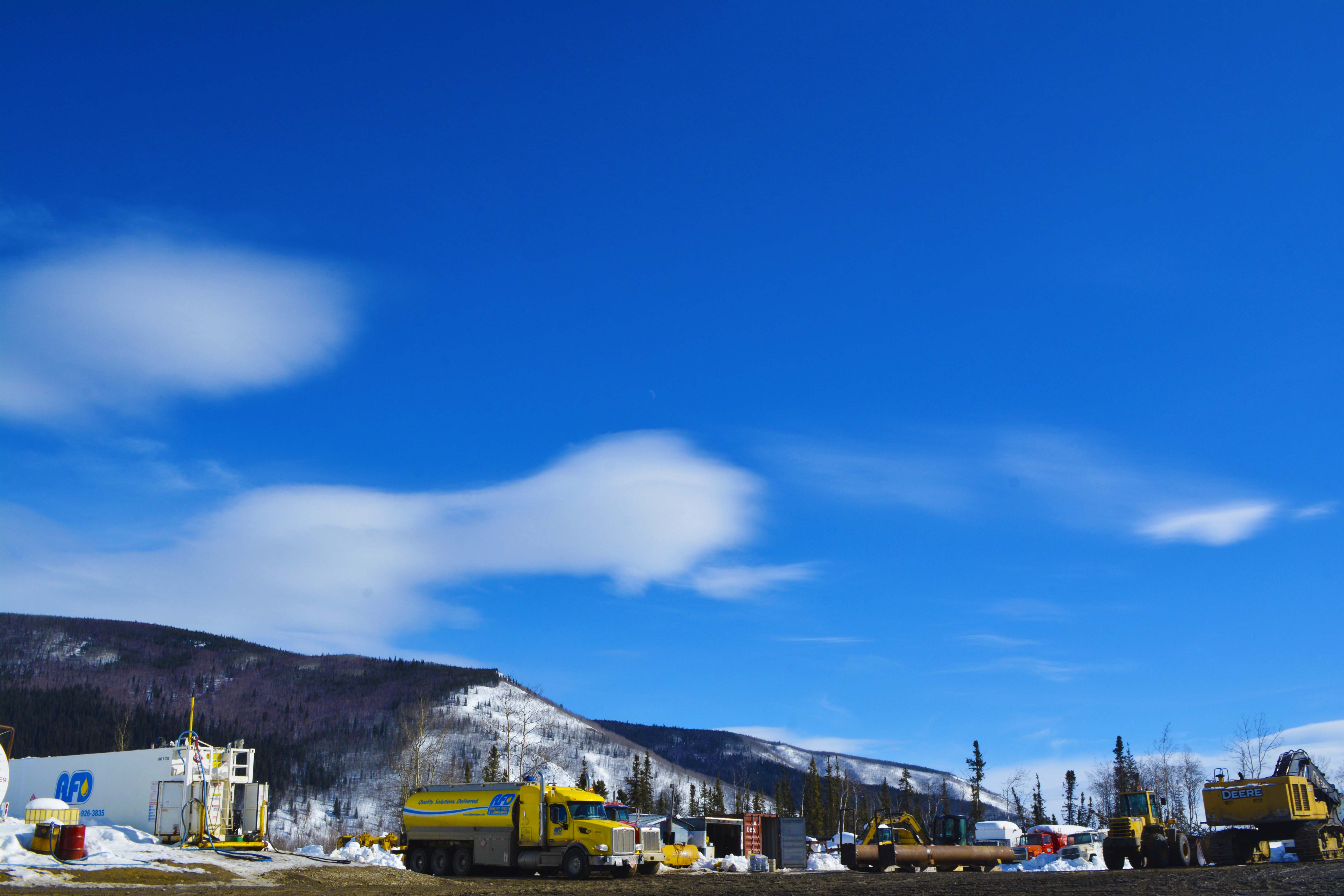 Wide view of an AFD Petroleum Yukon site with a fuel truck, equipment and a John Deere loader