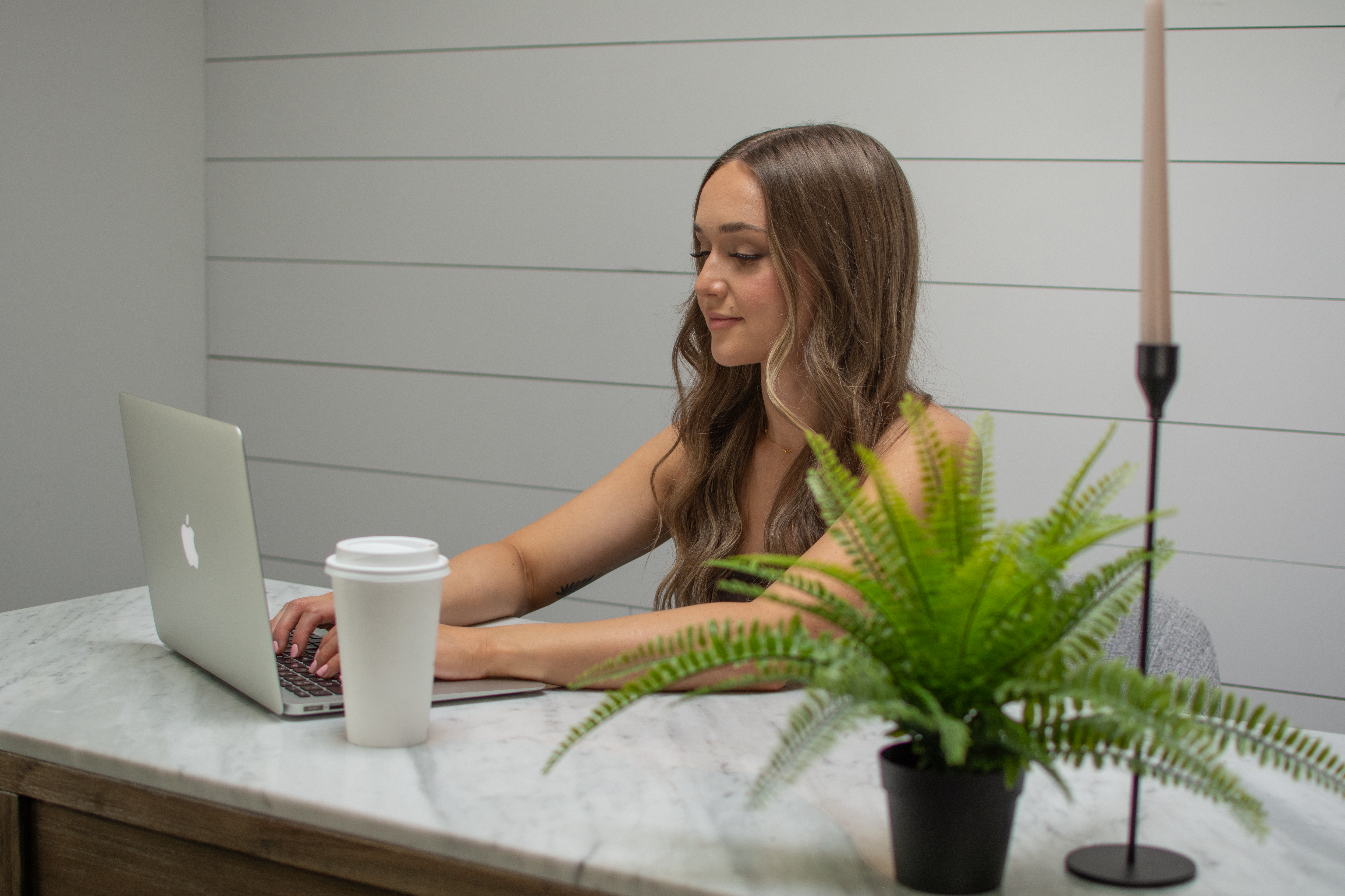 Star Remedy   working at laptop with coffee and plant on marble desk