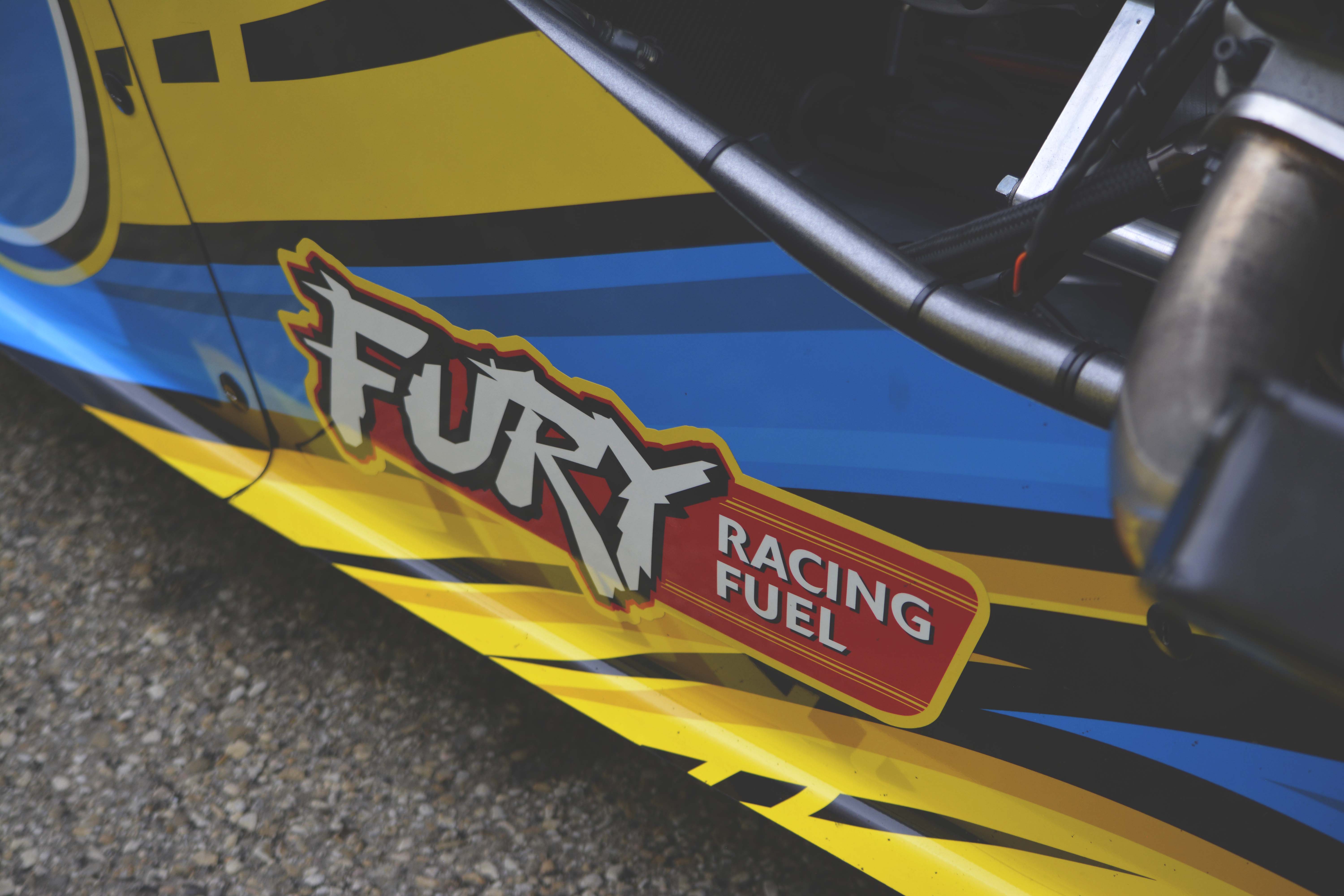 Close-up of AFD dragster bodywork with FURY Racing Fuel logo and yellow and blue graphics