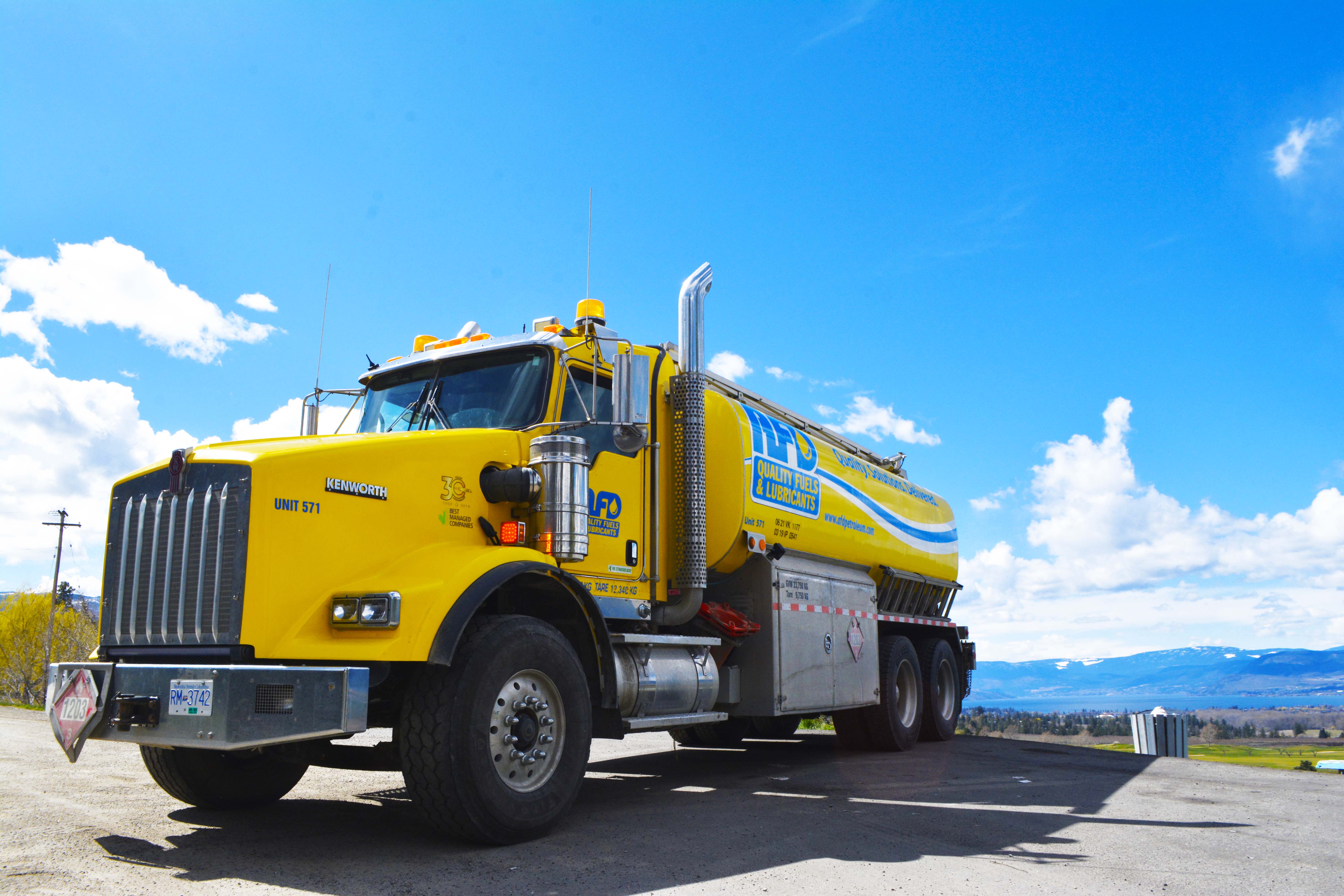 Yellow AFD Petroleum tanker truck overlooking the valley and lake near Kelowna