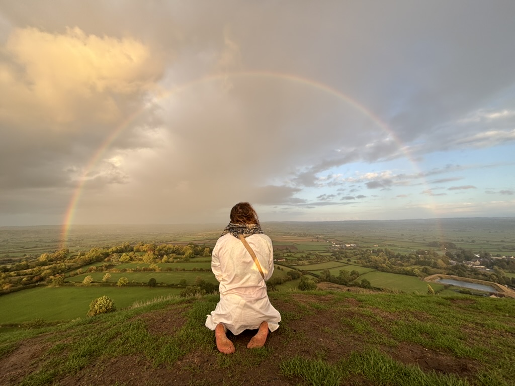 Luke Ram on Glastonbury Tor under a full rainbow