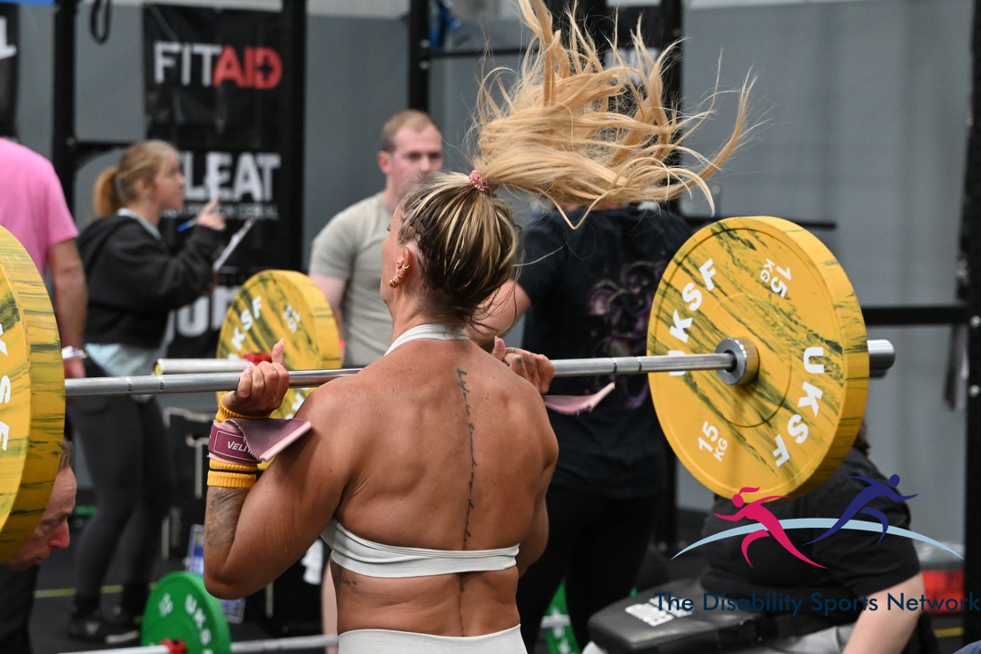 Athlete performing a barbell back squat loaded with yellow 15kg plates at Alt Movement
