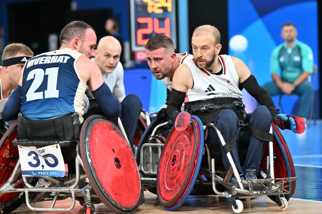GBR and FRA wheelchair rugby players in tight mid-court confrontation at Paris 2024 Paralympics