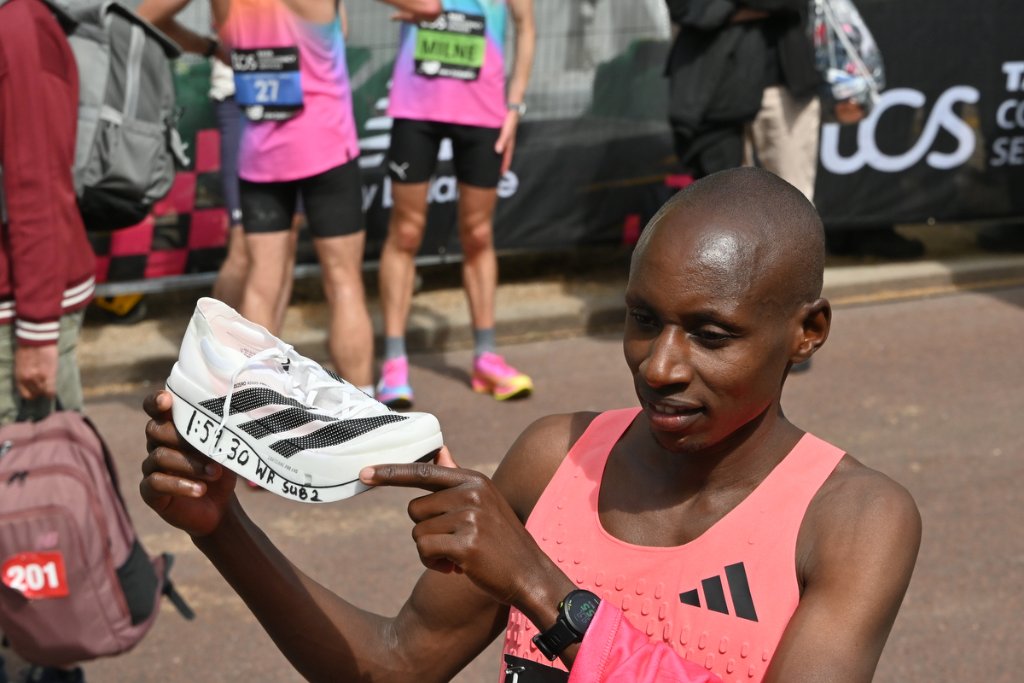 Athlete holding shoe with world record time written on it, London Marathon 2026